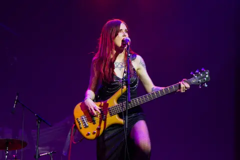 A live music performance under purple stage lights at an AFIN festival night.